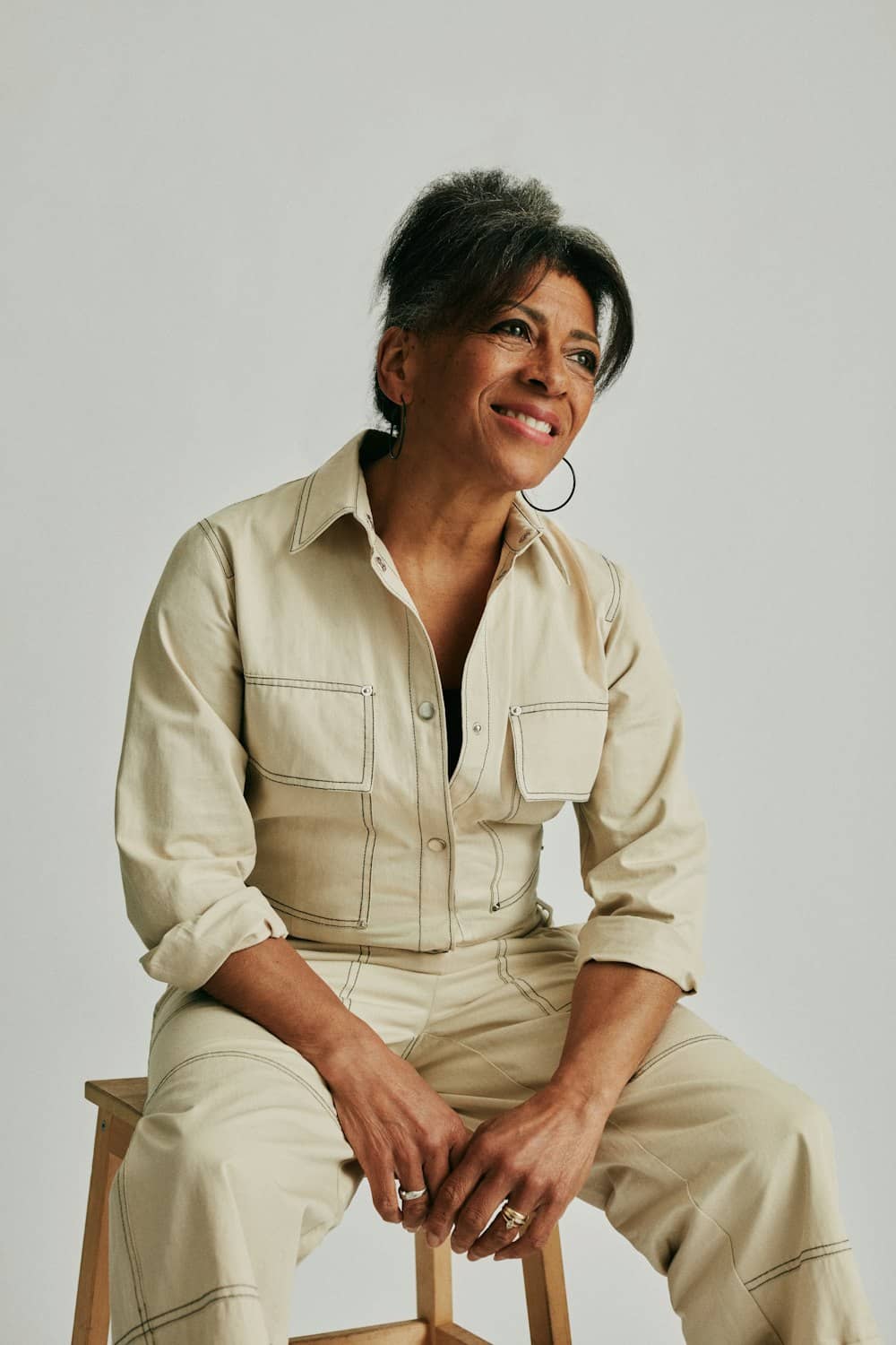 A woman in her early sixties with healthy, natural skin, photographed in soft studio light