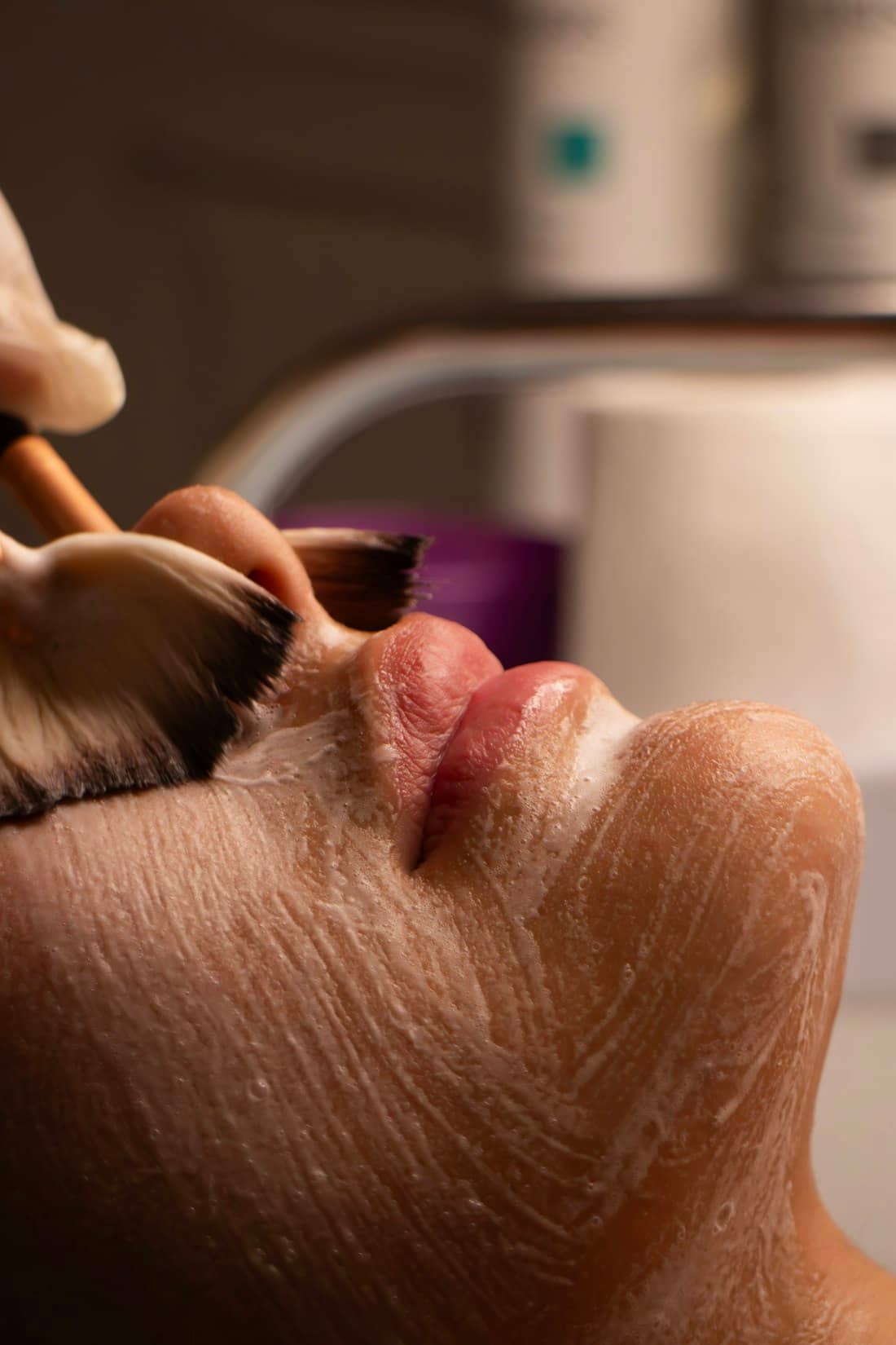 A peel solution brushed across a client's jaw with soft fan brushes